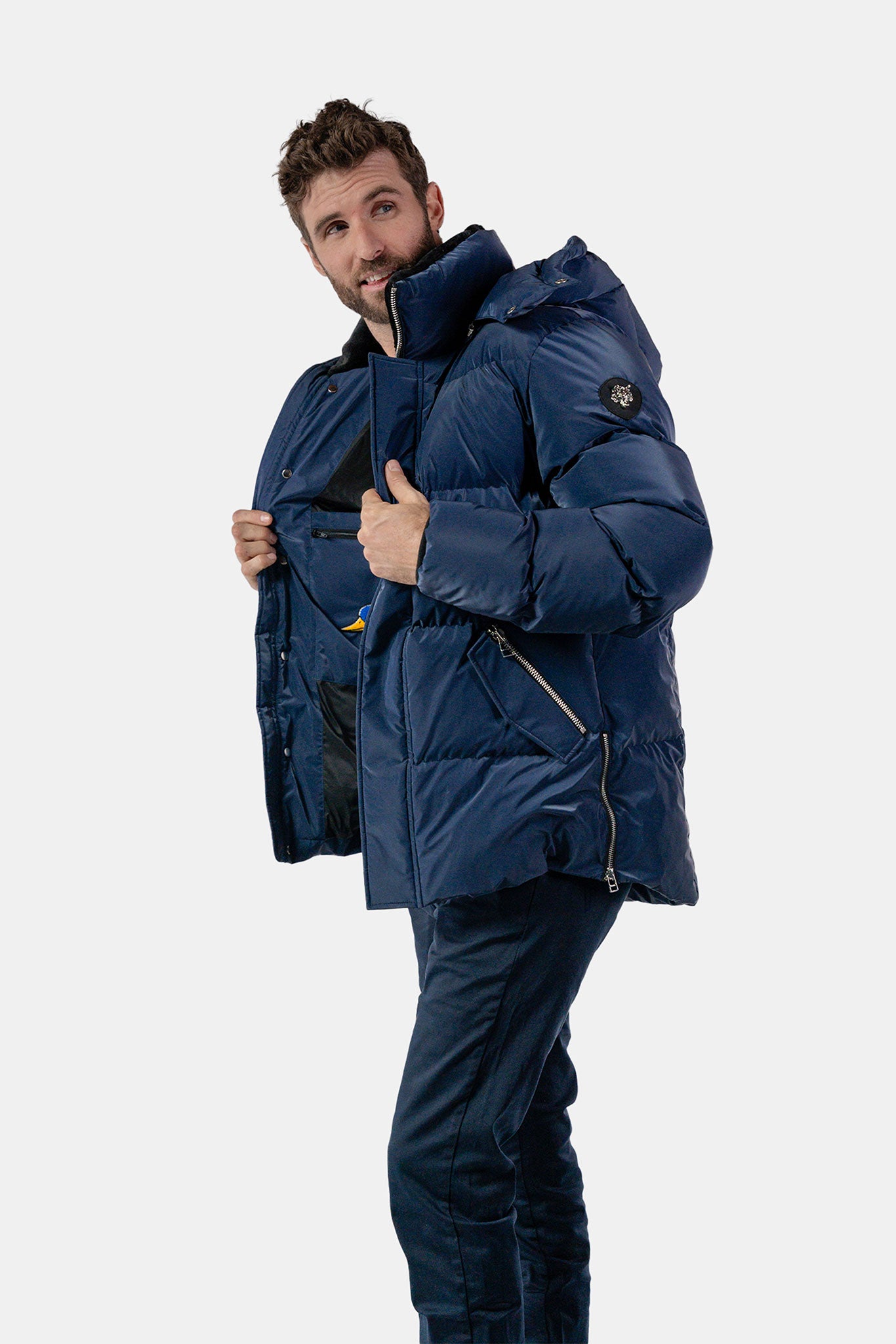 Woodpecker Men's Bumnester Bomber Winter coat. High-end Canadian designer winter coat for men in "Sapphire Diamond" colour. Woodpecker cruelty-free winter coat designed in Canada. Men's heavy weight medium length premium designer jacket for winter. Superior quality warm winter coat for men. Moose Knuckles, Canada Goose, Mackage, Montcler, Will Poho, Willbird, Nic Bayley. Shiny parka. Stylish winter jacket. Designer winter coat.