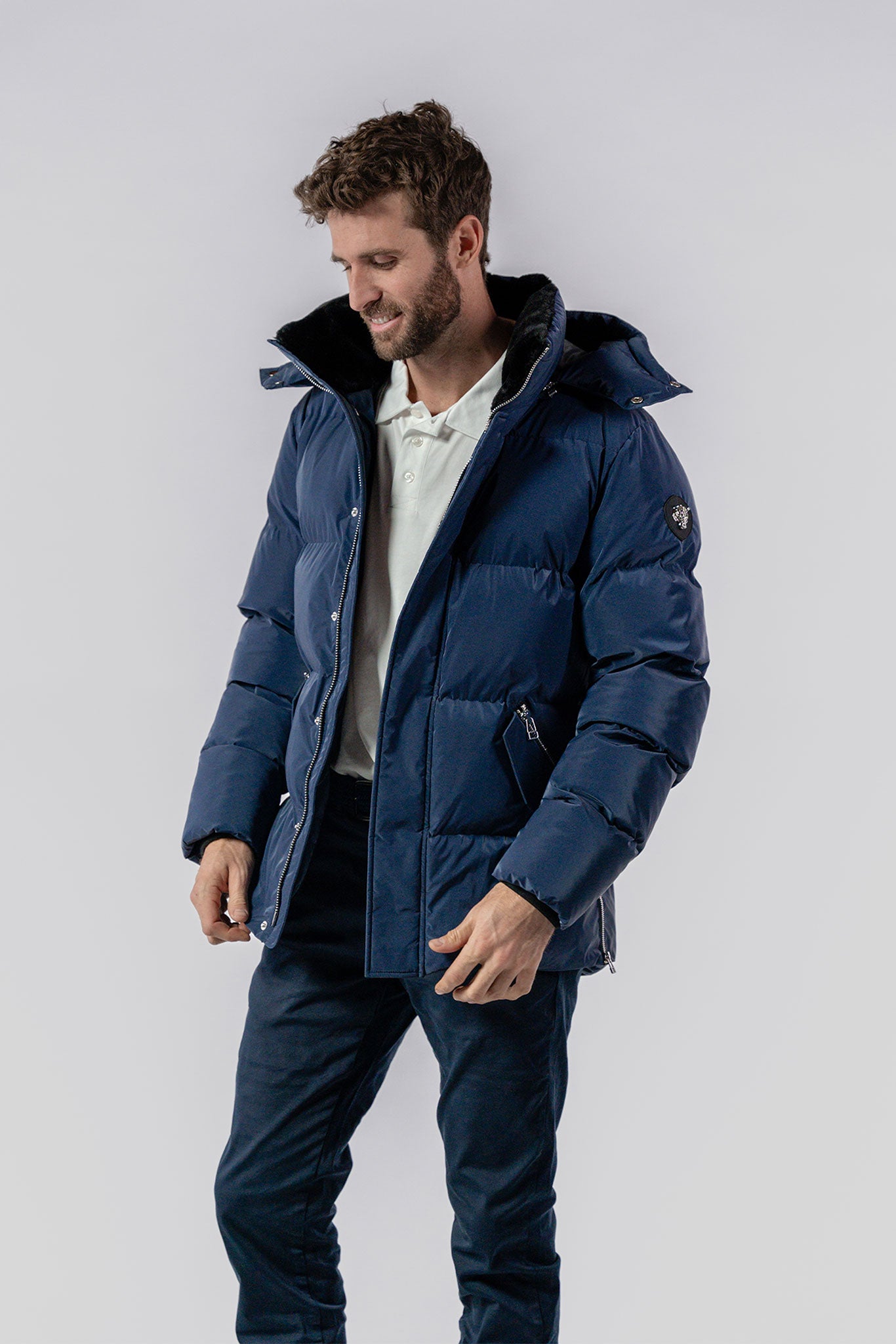 Woodpecker Men's Bumnester Bomber Winter coat. High-end Canadian designer winter coat for men in "Sapphire Diamond" colour. Woodpecker cruelty-free winter coat designed in Canada. Men's heavy weight medium length premium designer jacket for winter. Superior quality warm winter coat for men. Moose Knuckles, Canada Goose, Mackage, Montcler, Will Poho, Willbird, Nic Bayley. Shiny parka. Stylish winter jacket. Designer winter coat.