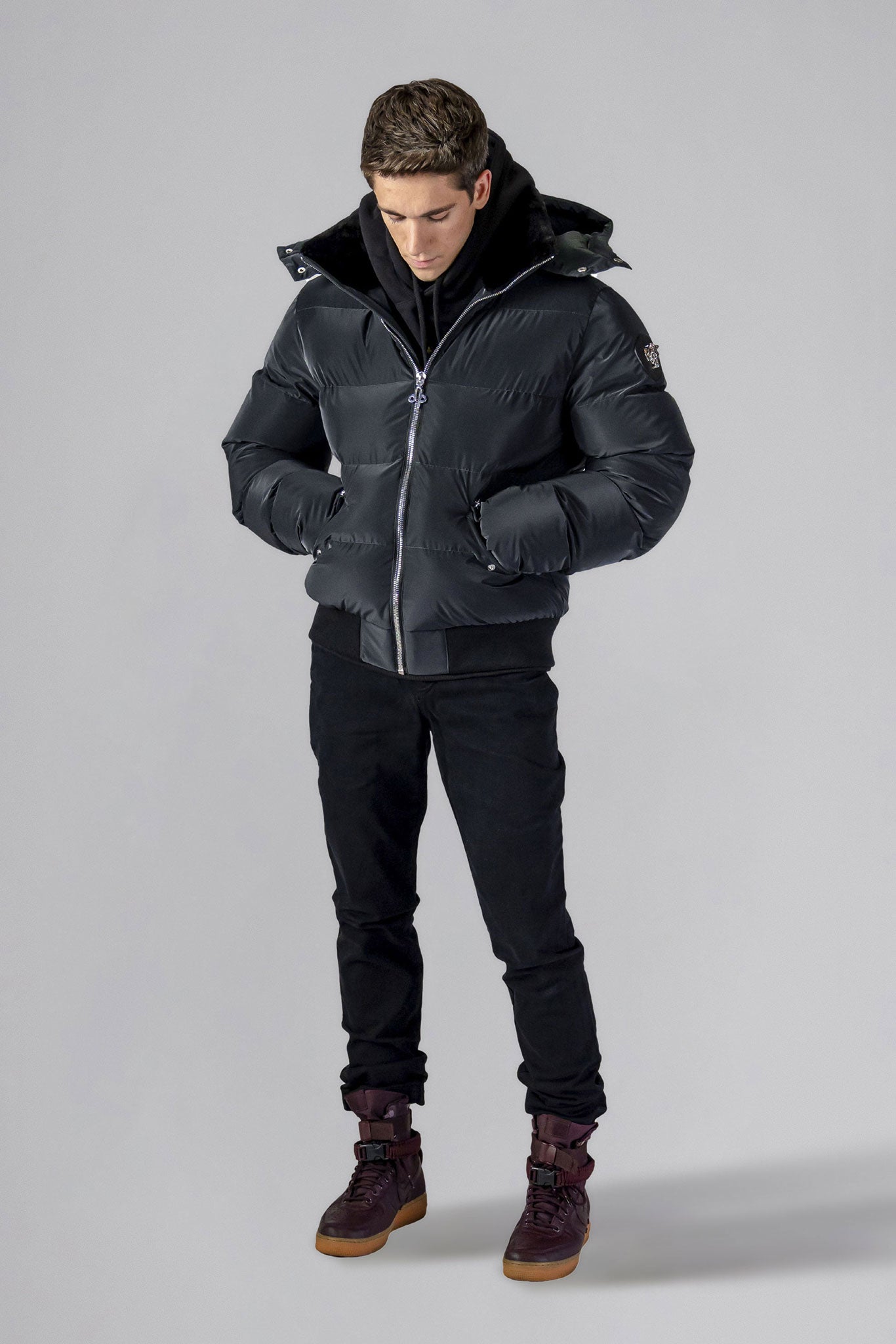 Woodpecker Men's Woody Bomber Winter coat. High-end Canadian designer winter coat for men in "Black Diamond" colour. Woodpecker cruelty-free winter coat designed in Canada. Men's heavy weight short length premium designer jacket for winter. Superior quality warm winter coat for men. Moose Knuckles, Canada Goose, Mackage, Montcler, Will Poho, Willbird, Nic Bayley. Shiny parka. Stylish winter jacket. Designer winter coat.