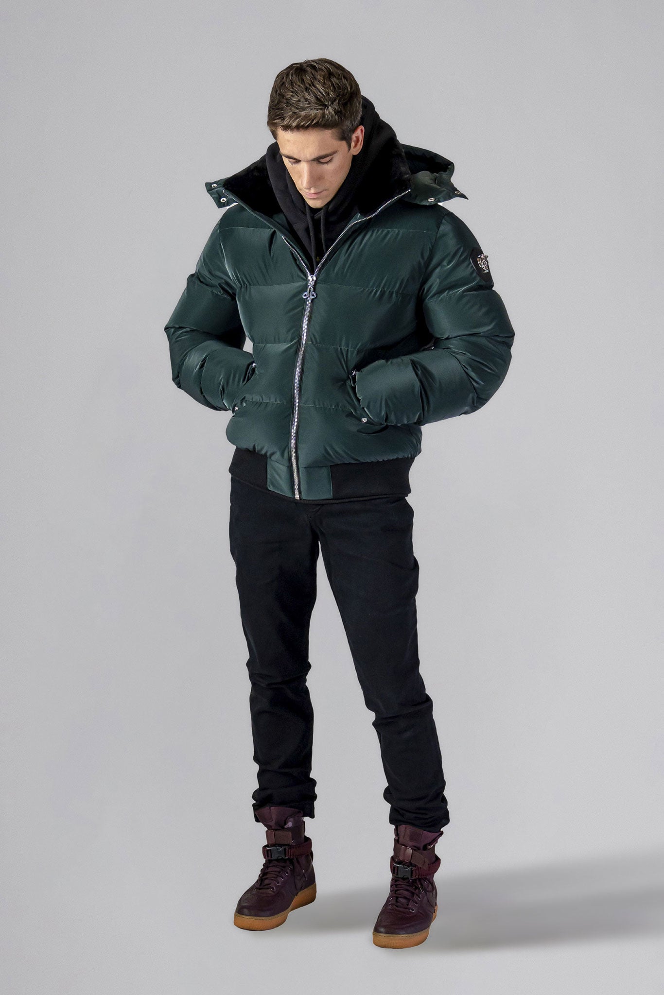 Woodpecker Men's Woody Bomber Winter coat. High-end Canadian designer winter coat for men in "Green Diamond" colour. Woodpecker cruelty-free winter coat designed in Canada. Men's heavy weight short length premium designer jacket for winter. Superior quality warm winter coat for men. Moose Knuckles, Canada Goose, Mackage, Montcler, Will Poho, Willbird, Nic Bayley. Shiny parka. Stylish winter jacket. Designer winter coat.