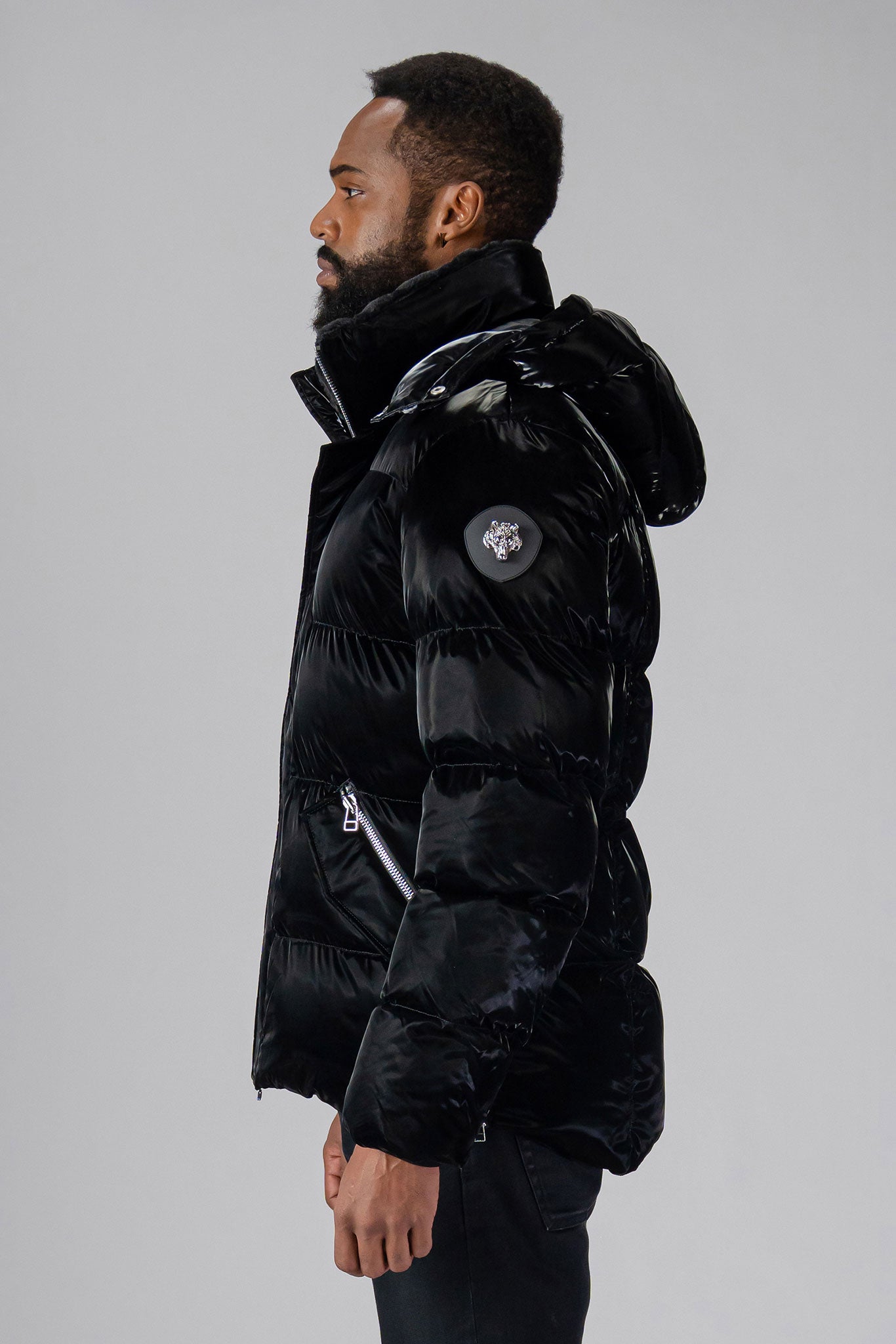 Woodpecker Men's Bumnester Winter coat. High-end Canadian designer winter coat for men in "All Wet Black" colour. Woodpecker cruelty-free winter coat designed in Canada. Men's heavy weight medium length premium designer jacket for winter. Superior quality warm winter coat for men. Moose Knuckles, Canada Goose, Mackage, Montcler, Will Poho, Willbird, Nic Bayley. Shiny parka. Stylish winter jacket. Designer winter coat.