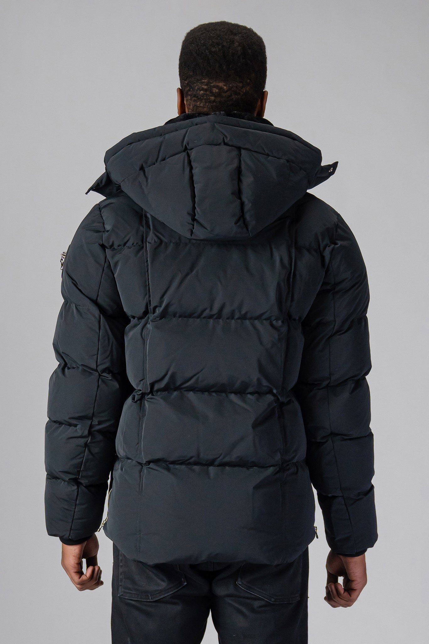 Woodpecker Men's Bumnester Winter coat. High-end Canadian designer winter coat for men in "Matte Black" colour. Woodpecker cruelty-free winter coat designed in Canada. Men's heavy weight medium length premium designer jacket for winter. Superior quality warm winter coat for men. Moose Knuckles, Canada Goose, Mackage, Montcler, Will Poho, Willbird, Nic Bayley. Shiny parka. Stylish winter jacket. Designer winter coat.