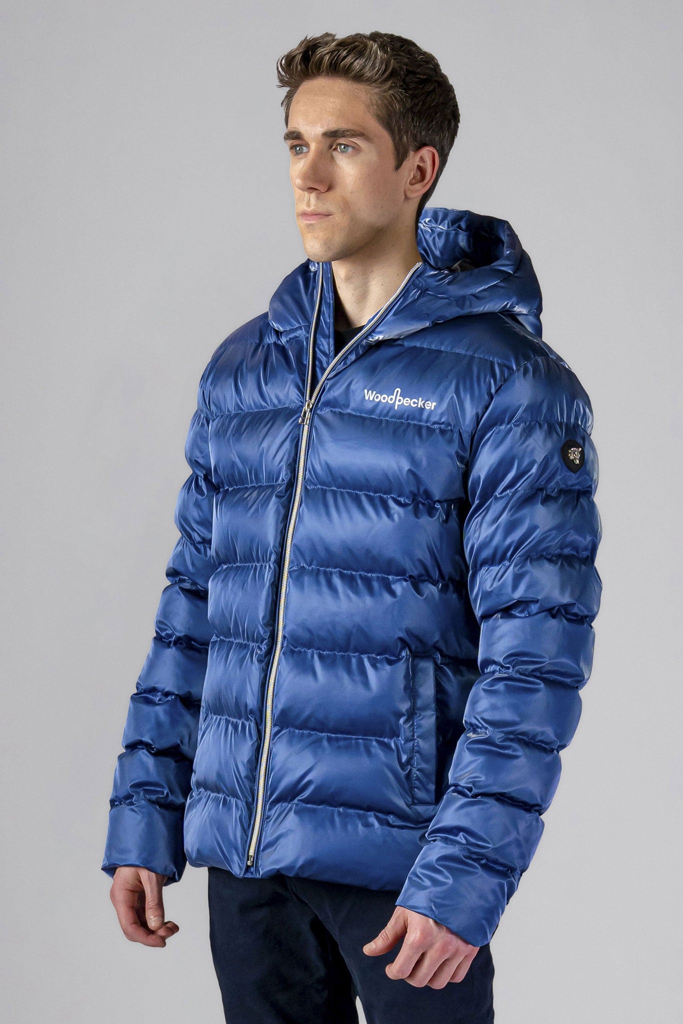 High-end Canadian designer winter coat for men in "Flash Blue" colour. Woodpecker cruelty-free winter coat designed in Canada. Men's medium weight medium length premium designer jacket for winter. Superior quality warm winter coat for men. Moose Knuckles, Canada Goose, Mackage, Montcler, Will Poho, Willbird, Nic Bayley. Shiny parka. Stylish winter jacket. Designer winter coat.