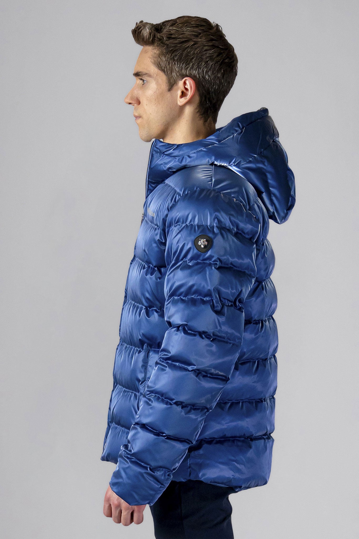 High-end Canadian designer winter coat for men in "Flash Blue" colour. Woodpecker cruelty-free winter coat designed in Canada. Men's medium weight medium length premium designer jacket for winter. Superior quality warm winter coat for men. Moose Knuckles, Canada Goose, Mackage, Montcler, Will Poho, Willbird, Nic Bayley. Shiny parka. Stylish winter jacket. Designer winter coat.