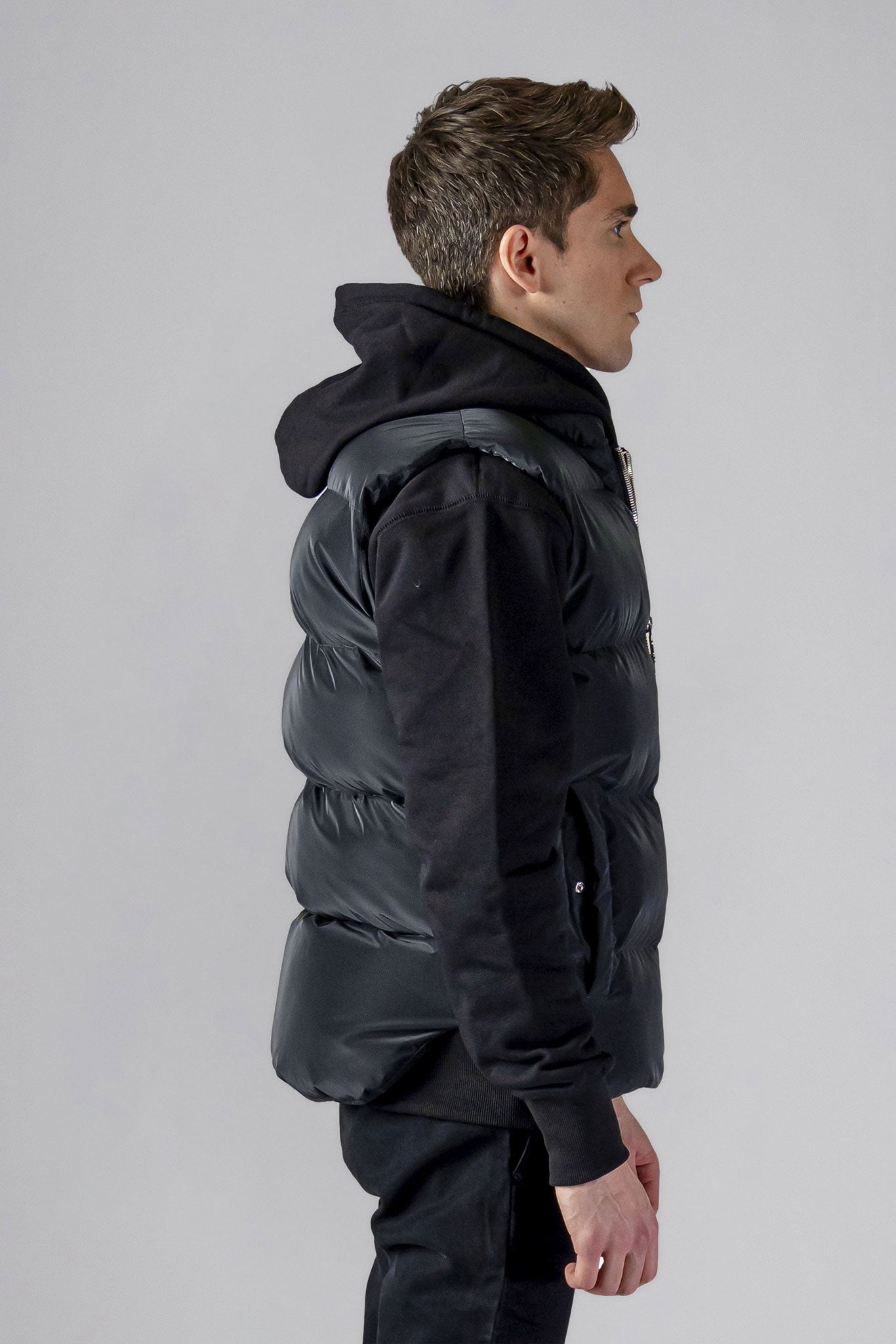 Woodpecker Unisex Winter Vest. High-end Canadian designer winter vest in "Black Diamond" colour. Woodpecker cruelty-free vest designed in Canada. Heavy weight short length premium designer vest for winter. Superior quality warm winter vest. Moose Knuckles, Canada Goose, Mackage, Montcler, Will Poho, Willbird, Nic Bayley. Extra warm. Shiny vest. Stylish winter vest. Designer winter vest.