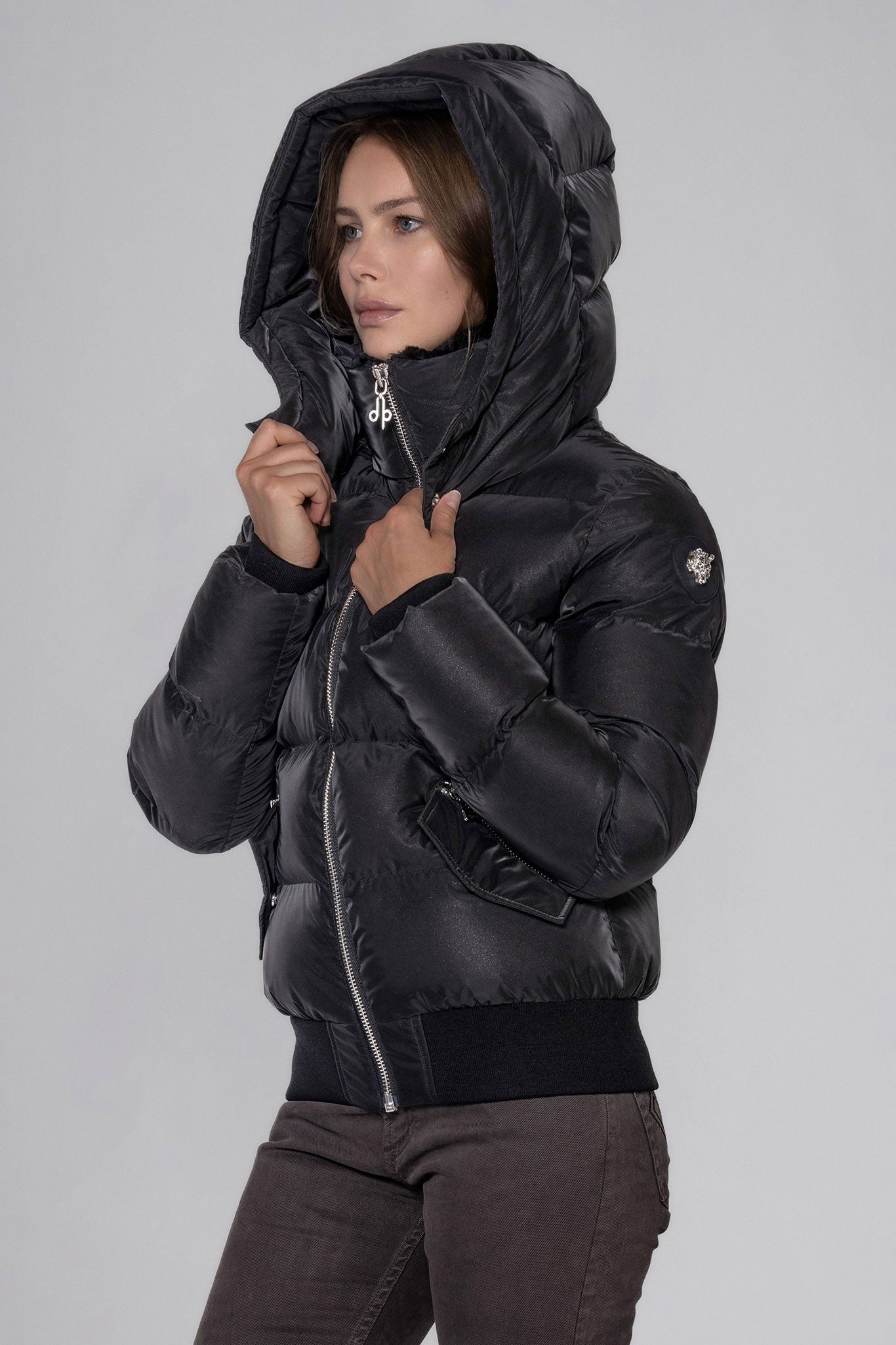 Woodpecker Women's Woody Bomber Winter coat. High-end Canadian designer winter coat for women in "Black Diamond" colour. Woodpecker cruelty-free winter coat designed in Canada. Women's heavy weight short length premium designer jacket for winter. Superior quality warm winter coat for women. Moose Knuckles, Canada Goose, Mackage, Montcler, Will Poho, Willbird, Nic Bayley. Shiny parka. Stylish winter jacket. Designer winter coat.