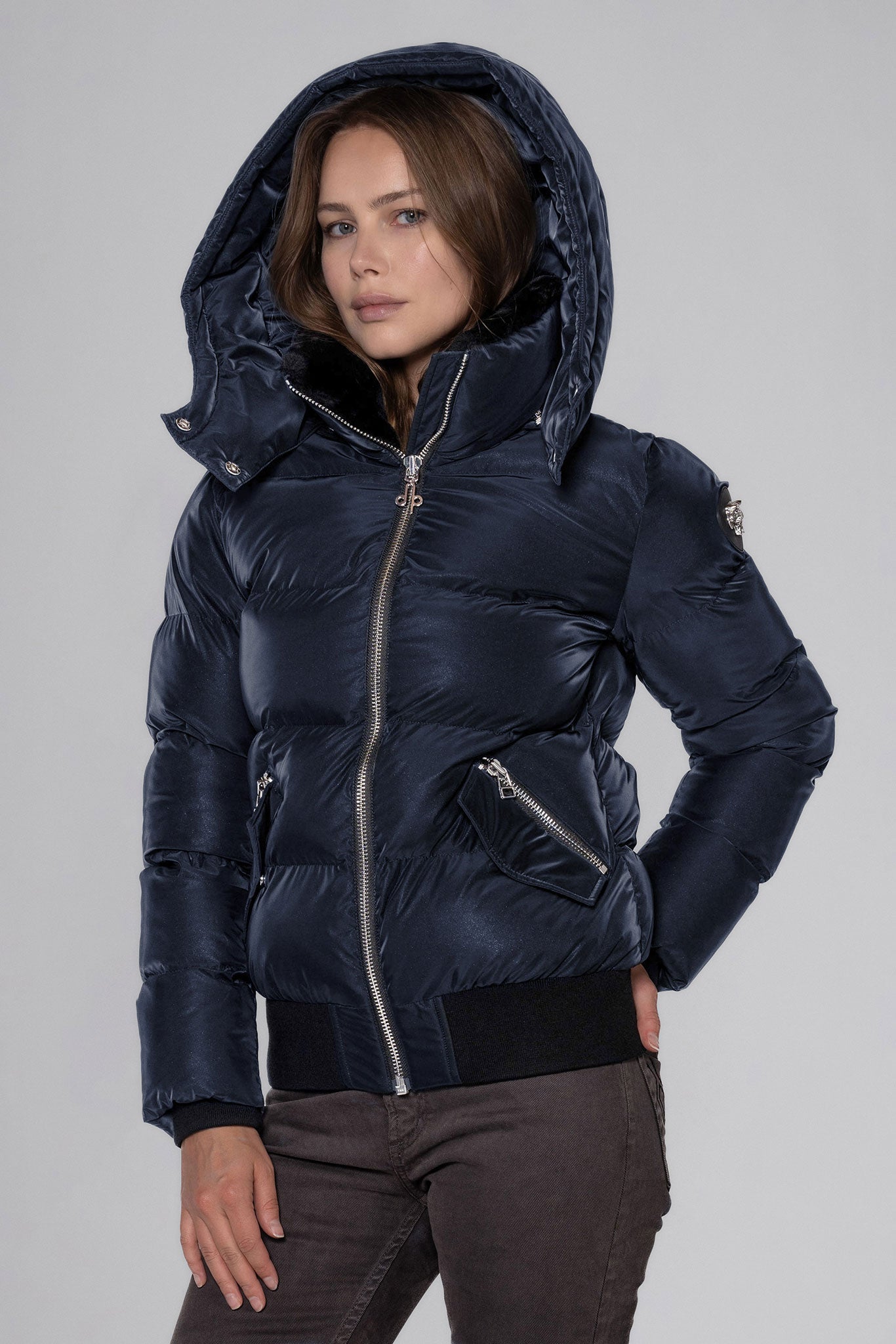 Woodpecker Women's Woody Bomber Winter coat. High-end Canadian designer winter coat for women in "Blue Diamond" colour. Woodpecker cruelty-free winter coat designed in Canada. Women's heavy weight short length premium designer jacket for winter. Superior quality warm winter coat for women. Moose Knuckles, Canada Goose, Mackage, Montcler, Will Poho, Willbird, Nic Bayley. Shiny parka. Stylish winter jacket. Designer winter coat.