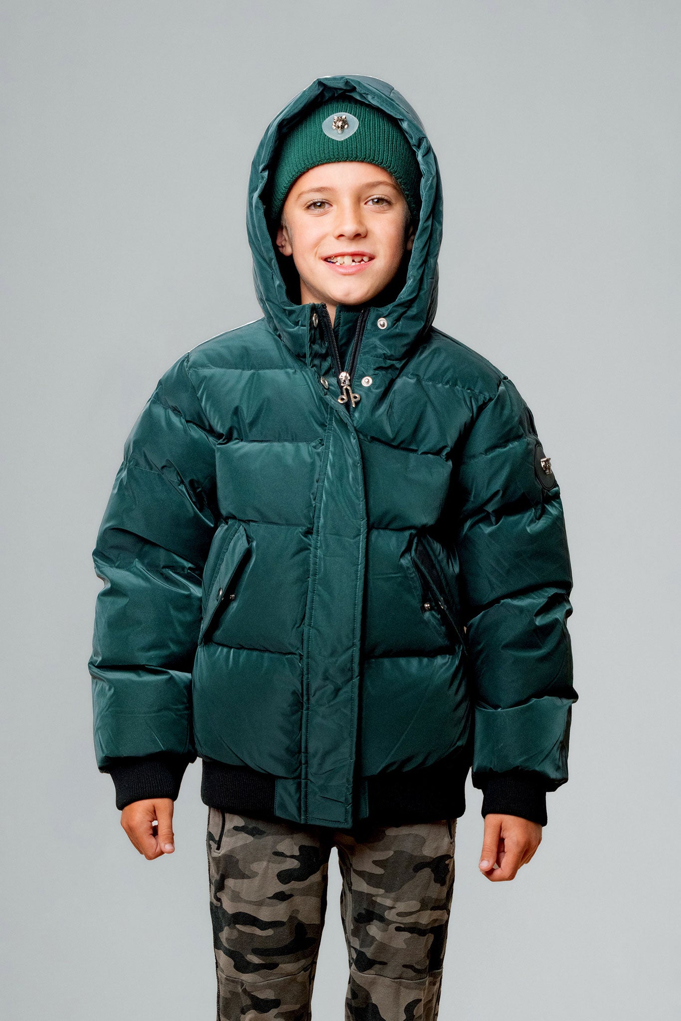 Woodpecker Kids' Chickadee Winter coat. High-end Canadian designer winter coat for Kids in "Green Diamond" colour. Woodpecker cruelty-free winter coat designed in Canada. Kids' heavy weight short length premium designer jacket for winter. Superior quality warm winter coat for kids. Moose Knuckles, Canada Goose, Mackage, Montcler, Will Poho, Willbird, Nic Bayley. Extra warm. Shiny parka. Stylish winter jacket. Designer winter coat.