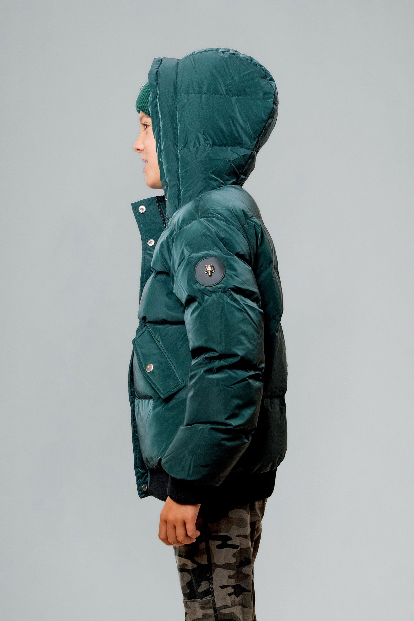 Woodpecker Kids' Chickadee Winter coat. High-end Canadian designer winter coat for Kids in "Green Diamond" colour. Woodpecker cruelty-free winter coat designed in Canada. Kids' heavy weight short length premium designer jacket for winter. Superior quality warm winter coat for kids. Moose Knuckles, Canada Goose, Mackage, Montcler, Will Poho, Willbird, Nic Bayley. Extra warm. Shiny parka. Stylish winter jacket. Designer winter coat.