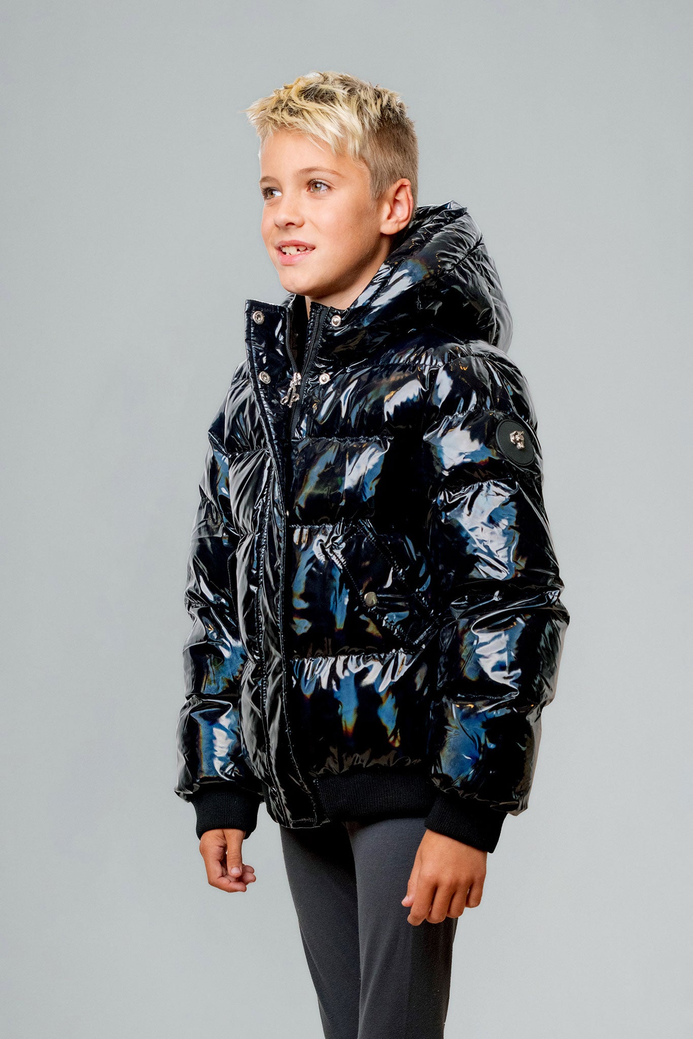 Woodpecker Kids' Chickadee Winter coat. High-end Canadian designer winter coat for Kids in "Oily Black" colour. Woodpecker cruelty-free winter coat designed in Canada. Kids' heavy weight short length premium designer jacket for winter. Superior quality warm winter coat for kids. Moose Knuckles, Canada Goose, Mackage, Montcler, Will Poho, Willbird, Nic Bayley. Extra Warm. Shiny parka. Stylish winter jacket. Designer winter coat.