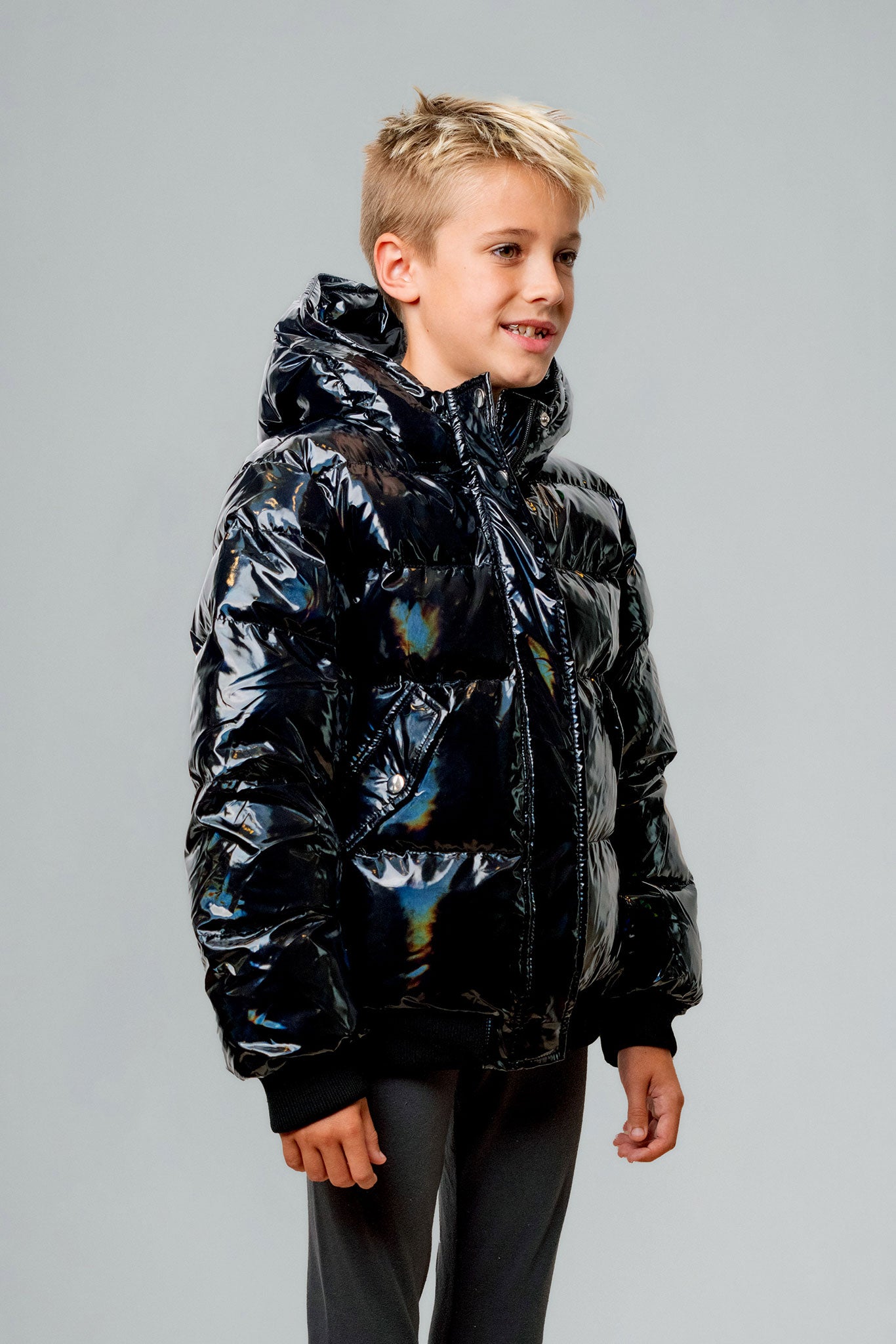 Woodpecker Kids' Chickadee Winter coat. High-end Canadian designer winter coat for Kids in "Oily Black" colour. Woodpecker cruelty-free winter coat designed in Canada. Kids' heavy weight short length premium designer jacket for winter. Superior quality warm winter coat for kids. Moose Knuckles, Canada Goose, Mackage, Montcler, Will Poho, Willbird, Nic Bayley. Extra Warm. Shiny parka. Stylish winter jacket. Designer winter coat.