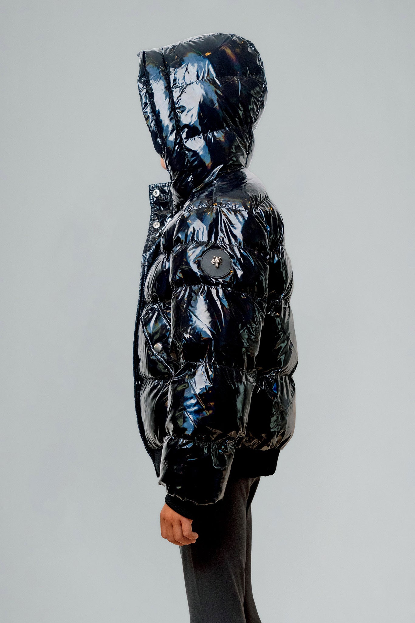 Woodpecker Kids' Chickadee Winter coat. High-end Canadian designer winter coat for Kids in "Oily Black" colour. Woodpecker cruelty-free winter coat designed in Canada. Kids' heavy weight short length premium designer jacket for winter. Superior quality warm winter coat for kids. Moose Knuckles, Canada Goose, Mackage, Montcler, Will Poho, Willbird, Nic Bayley. Extra Warm. Shiny parka. Stylish winter jacket. Designer winter coat.