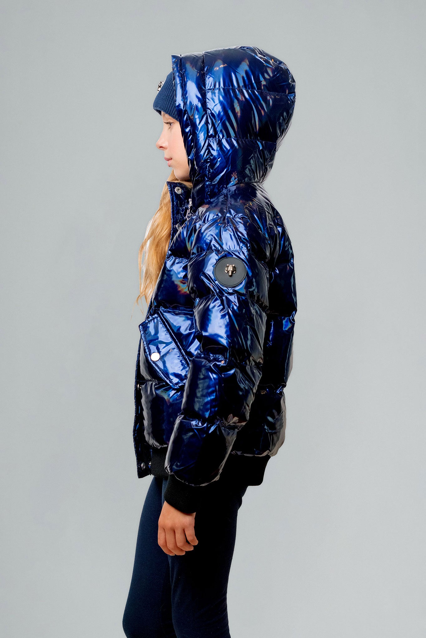 Woodpecker Kids' Chickadee Winter coat. High-end Canadian designer winter coat for Kids in "Oily Blue" colour. Woodpecker cruelty-free winter coat designed in Canada. Kids' heavy weight short length premium designer jacket for winter. Superior quality warm winter coat for kids. Moose Knuckles, Canada Goose, Mackage, Montcler, Will Poho, Willbird, Nic Bayley. Extra warm. Shiny parka. Stylish winter jacket. Designer winter coat.