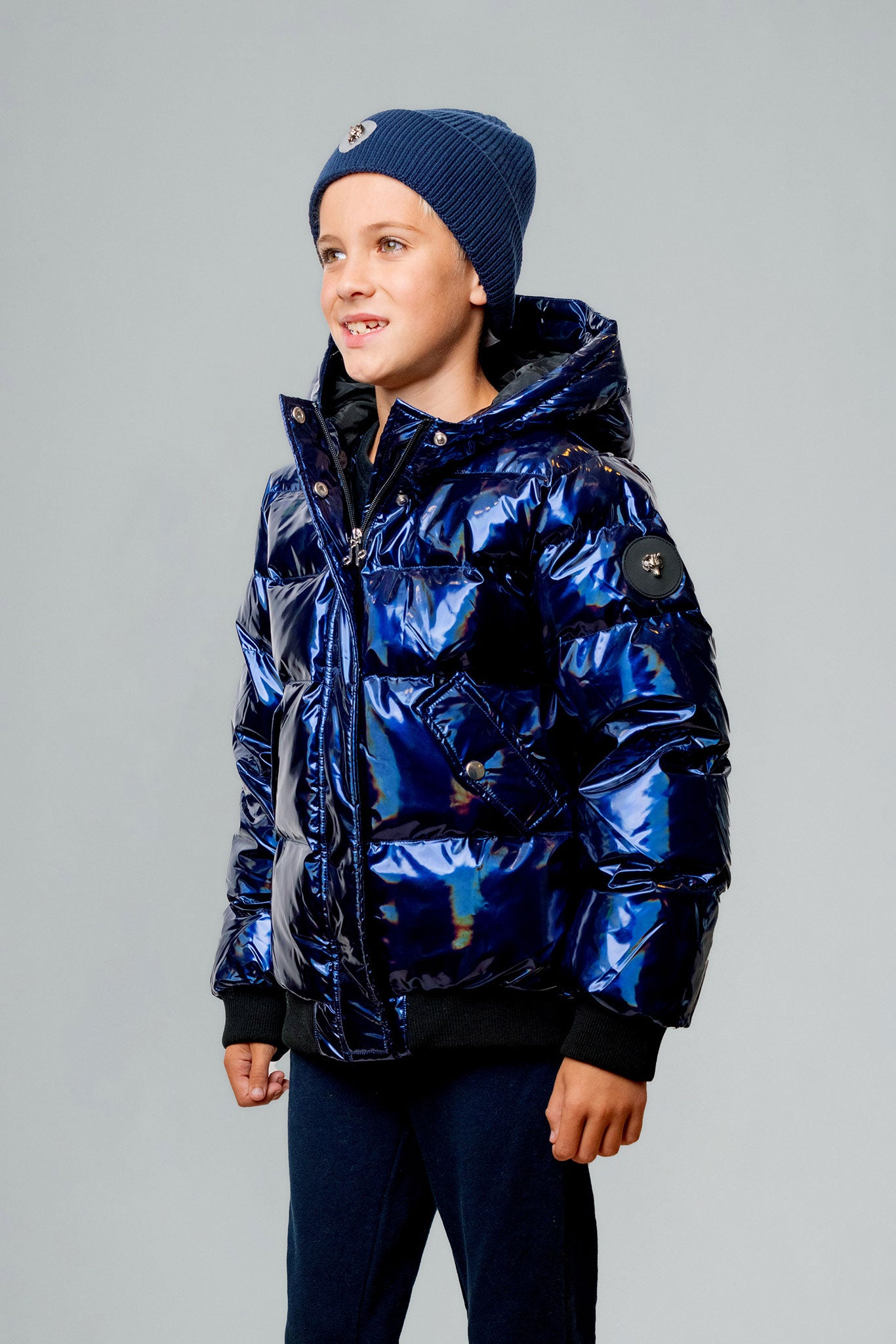 Woodpecker Kids' Chickadee Winter coat. High-end Canadian designer winter coat for Kids in "Oily Blue" colour. Woodpecker cruelty-free winter coat designed in Canada. Kids' heavy weight short length premium designer jacket for winter. Superior quality warm winter coat for kids. Moose Knuckles, Canada Goose, Mackage, Montcler, Will Poho, Willbird, Nic Bayley. Extra warm. Shiny parka. Stylish winter jacket. Designer winter coat.