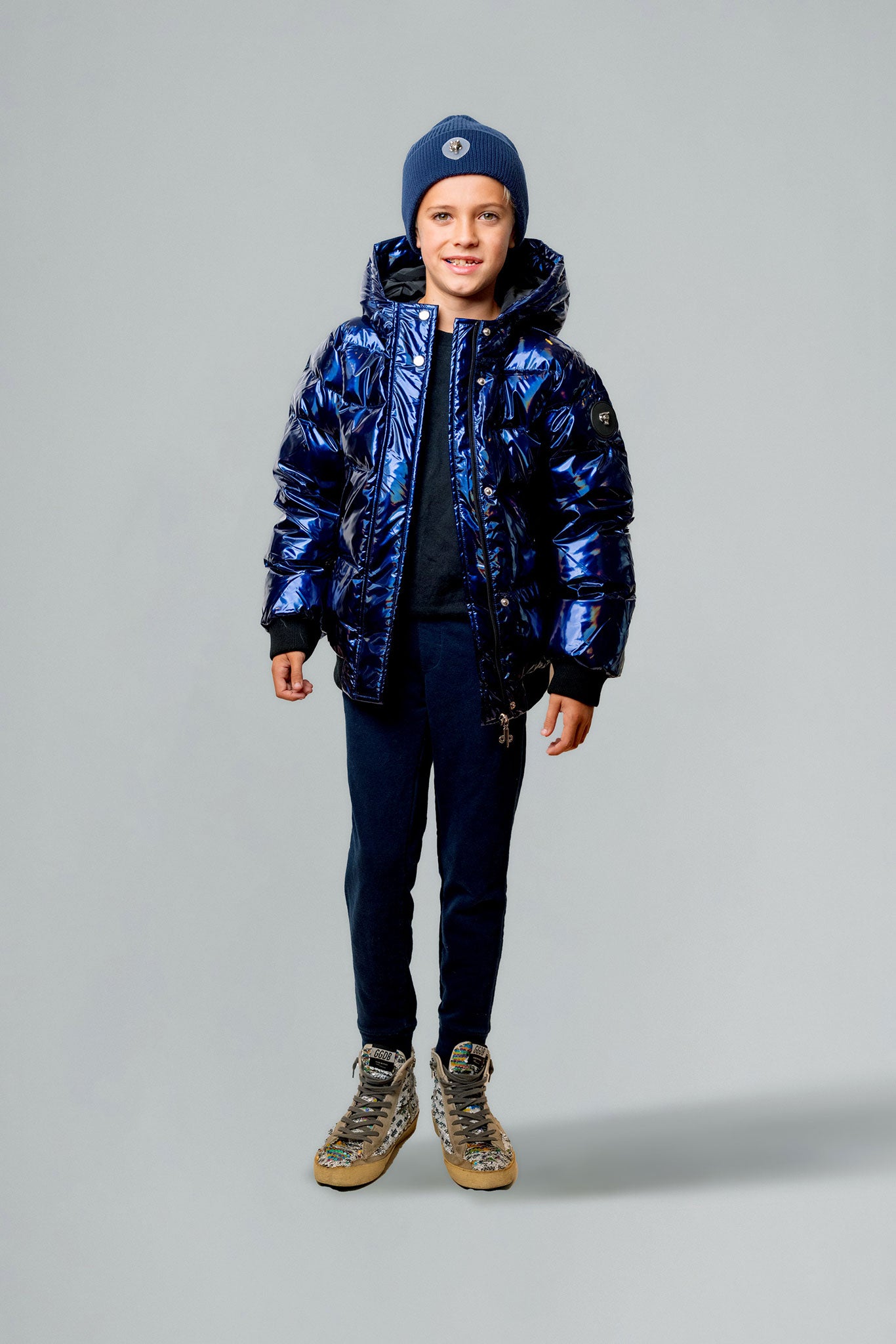 Woodpecker Kids' Chickadee Winter coat. High-end Canadian designer winter coat for Kids in "Oily Blue" colour. Woodpecker cruelty-free winter coat designed in Canada. Kids' heavy weight short length premium designer jacket for winter. Superior quality warm winter coat for kids. Moose Knuckles, Canada Goose, Mackage, Montcler, Will Poho, Willbird, Nic Bayley. Extra warm. Shiny parka. Stylish winter jacket. Designer winter coat.