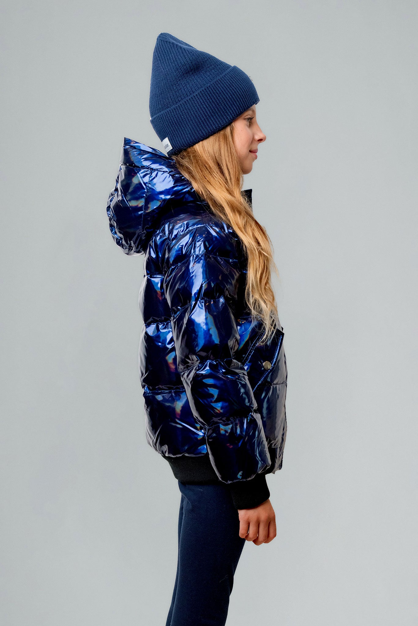 Woodpecker Kids' Chickadee Winter coat. High-end Canadian designer winter coat for Kids in "Oily Blue" colour. Woodpecker cruelty-free winter coat designed in Canada. Kids' heavy weight short length premium designer jacket for winter. Superior quality warm winter coat for kids. Moose Knuckles, Canada Goose, Mackage, Montcler, Will Poho, Willbird, Nic Bayley. Extra warm. Shiny parka. Stylish winter jacket. Designer winter coat.