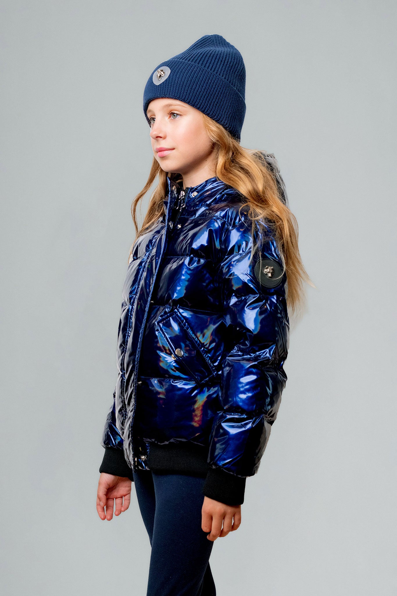 Woodpecker Kids' Chickadee Winter coat. High-end Canadian designer winter coat for Kids in "Oily Blue" colour. Woodpecker cruelty-free winter coat designed in Canada. Kids' heavy weight short length premium designer jacket for winter. Superior quality warm winter coat for kids. Moose Knuckles, Canada Goose, Mackage, Montcler, Will Poho, Willbird, Nic Bayley. Extra warm. Shiny parka. Stylish winter jacket. Designer winter coat.